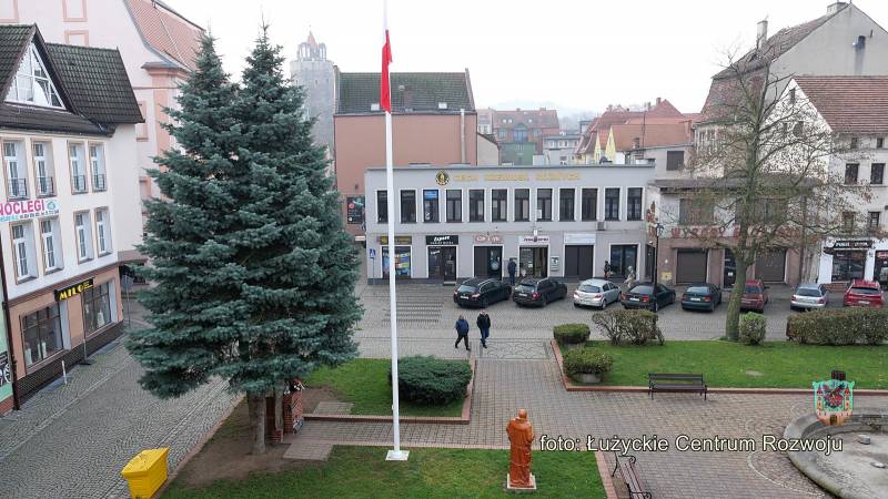 Maszt z flagą zamontowany na Placu Feliksa Netza, widok na centrum miasta